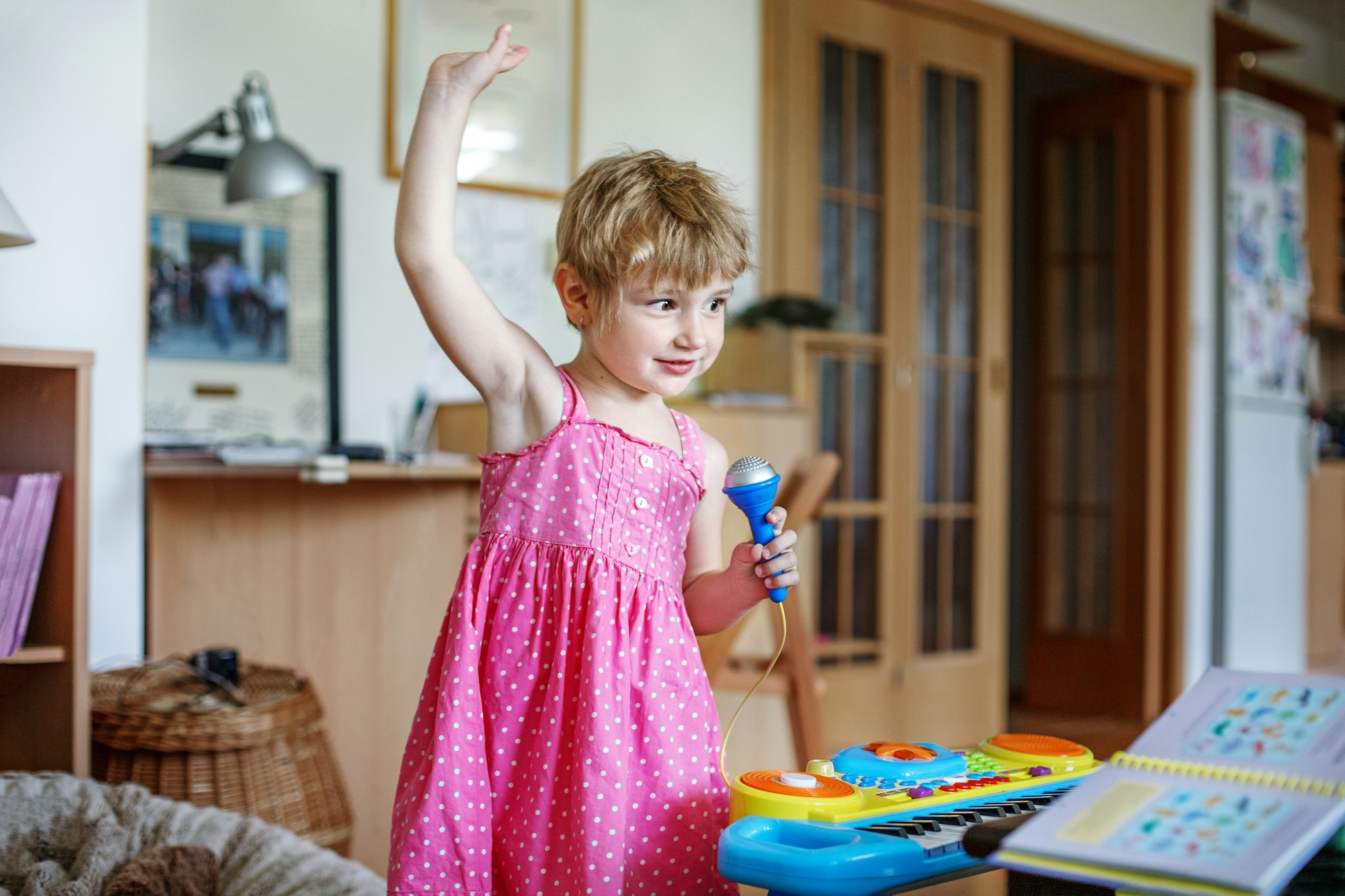 The little child dances and sings in the microphone. Conception
